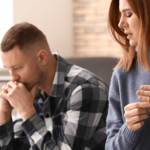 Couple sitting on sofa emotionally disconnected